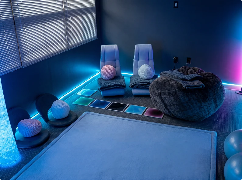 Sensory wellness room with immersive lighting, floor cushions, and calming elements