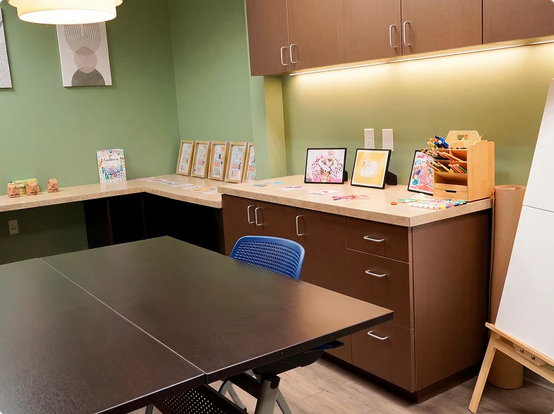 Skills-building classroom with whiteboard easel, worktables, and resource displays